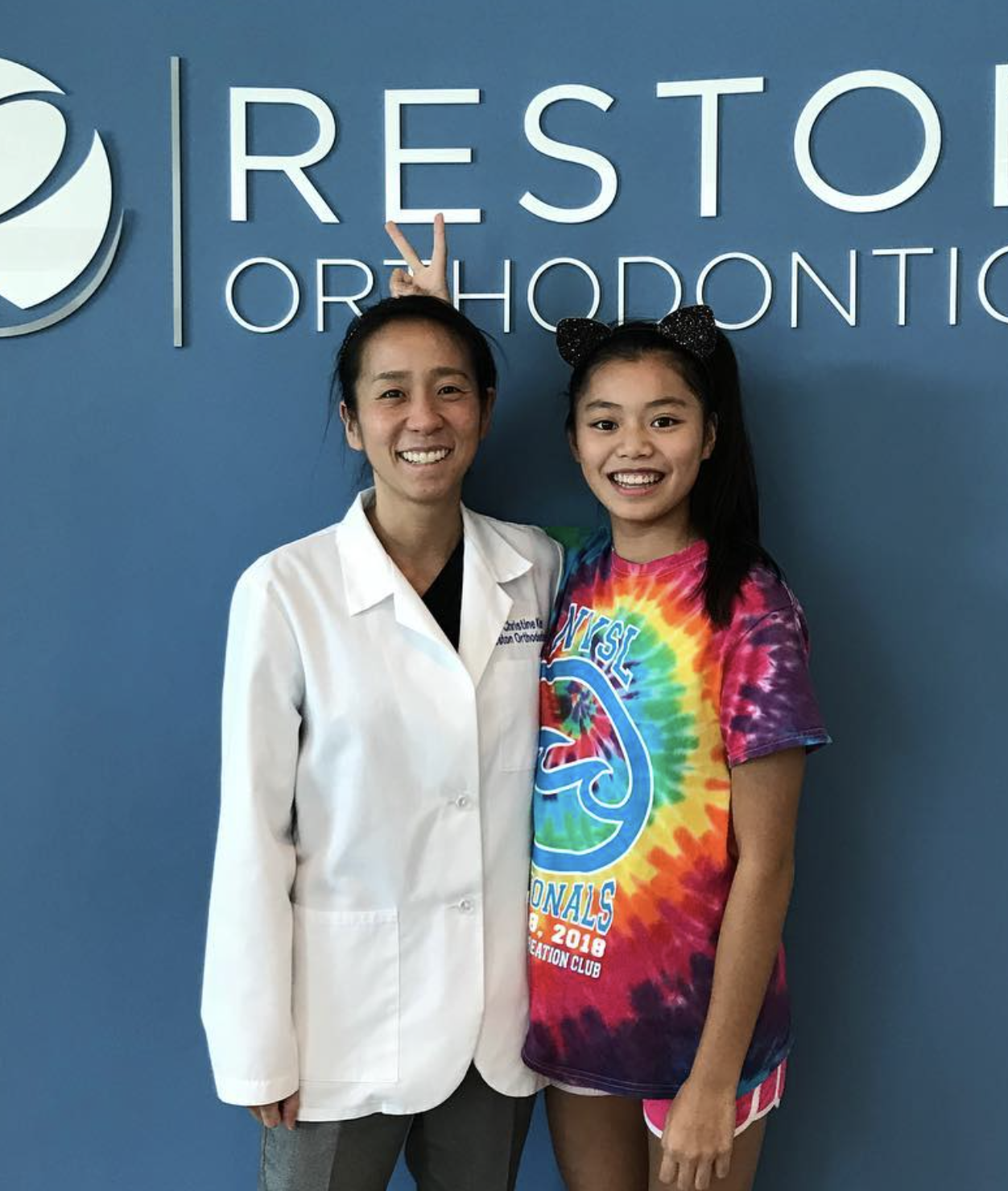 Dr. Kim with a smiling young patient after an orthodontic visit